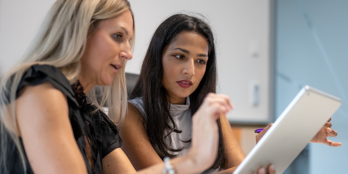 two businesswomen working on a tablet