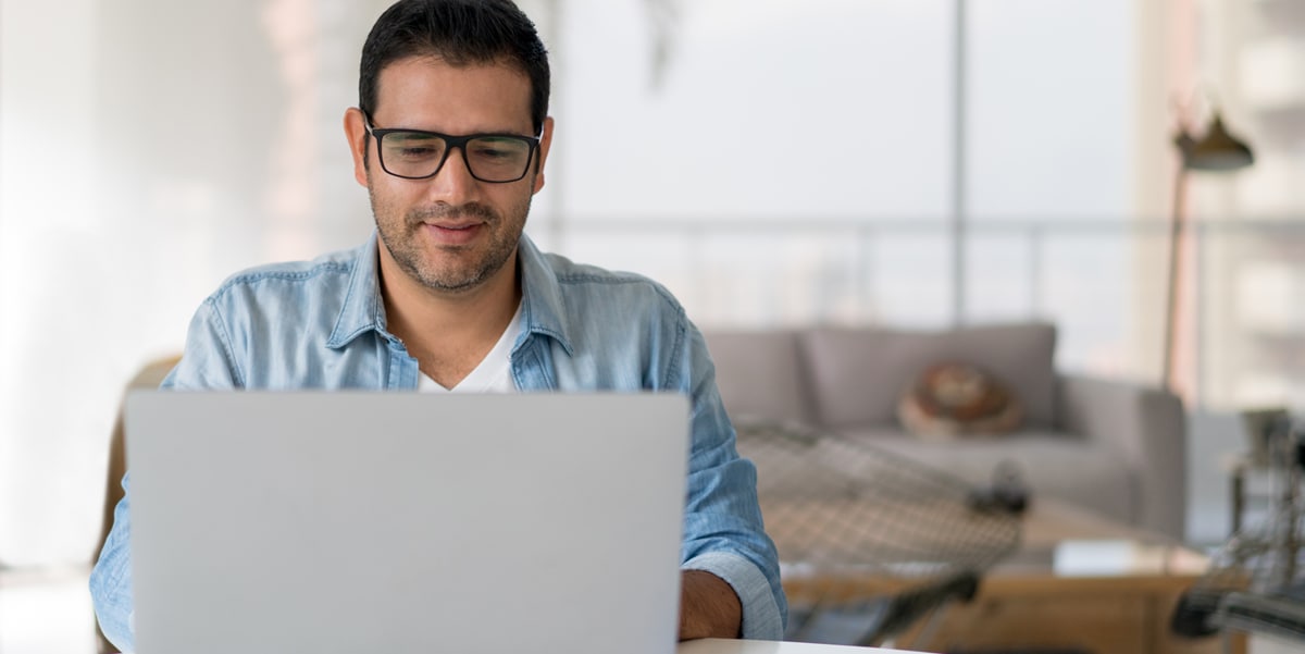 man in glasses working on his laptop