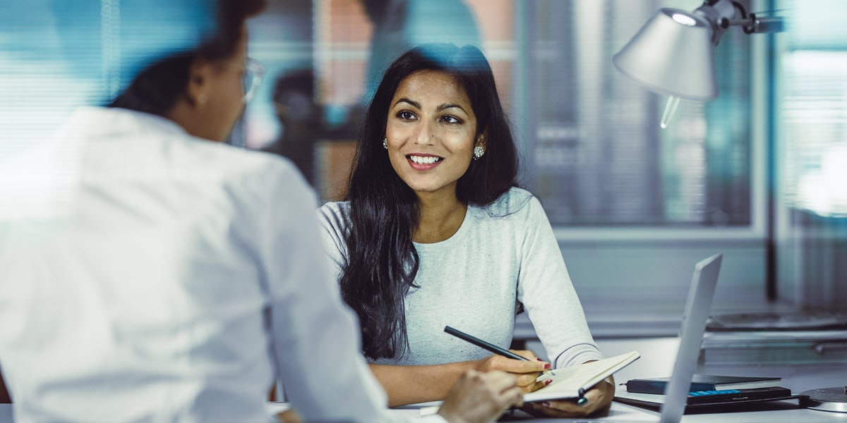 Businesswoman working at desk with feet up