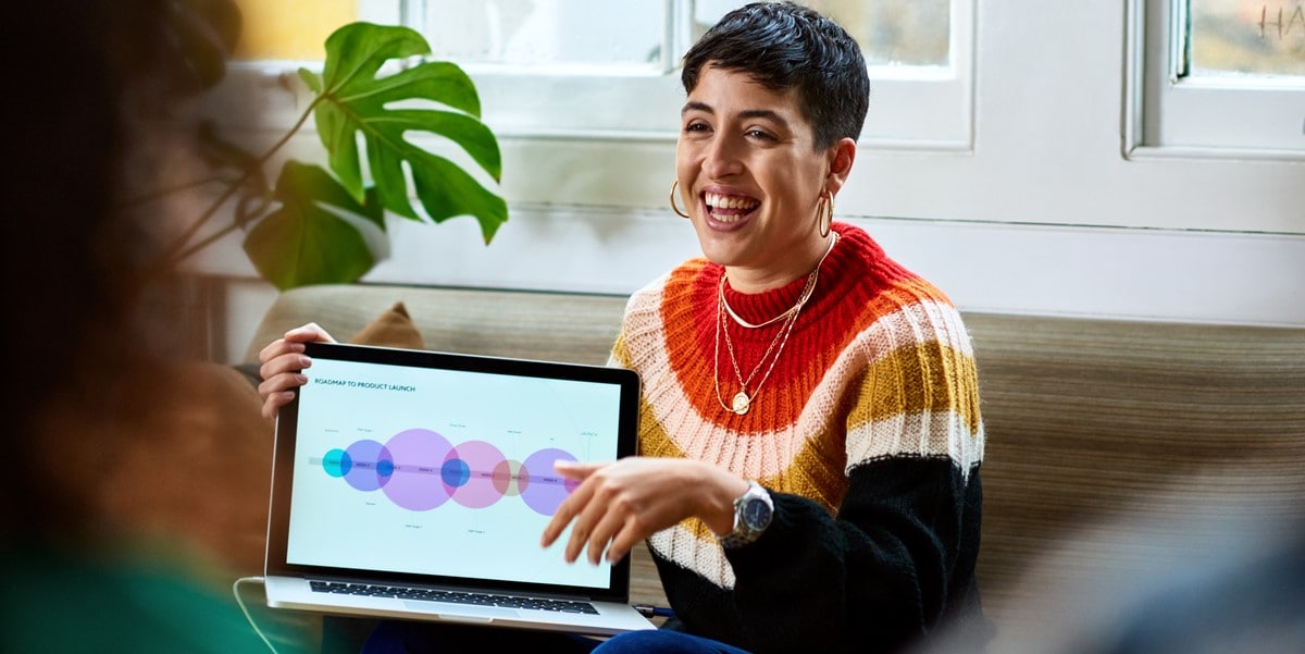 woman in office presenting chart on laptop