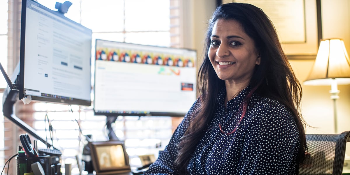 woman smiling at her desk at her home office