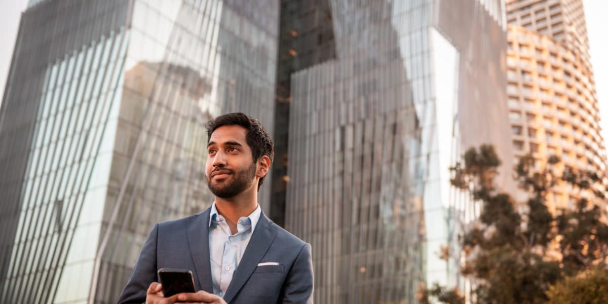 businessman outside next to skyscrapers 