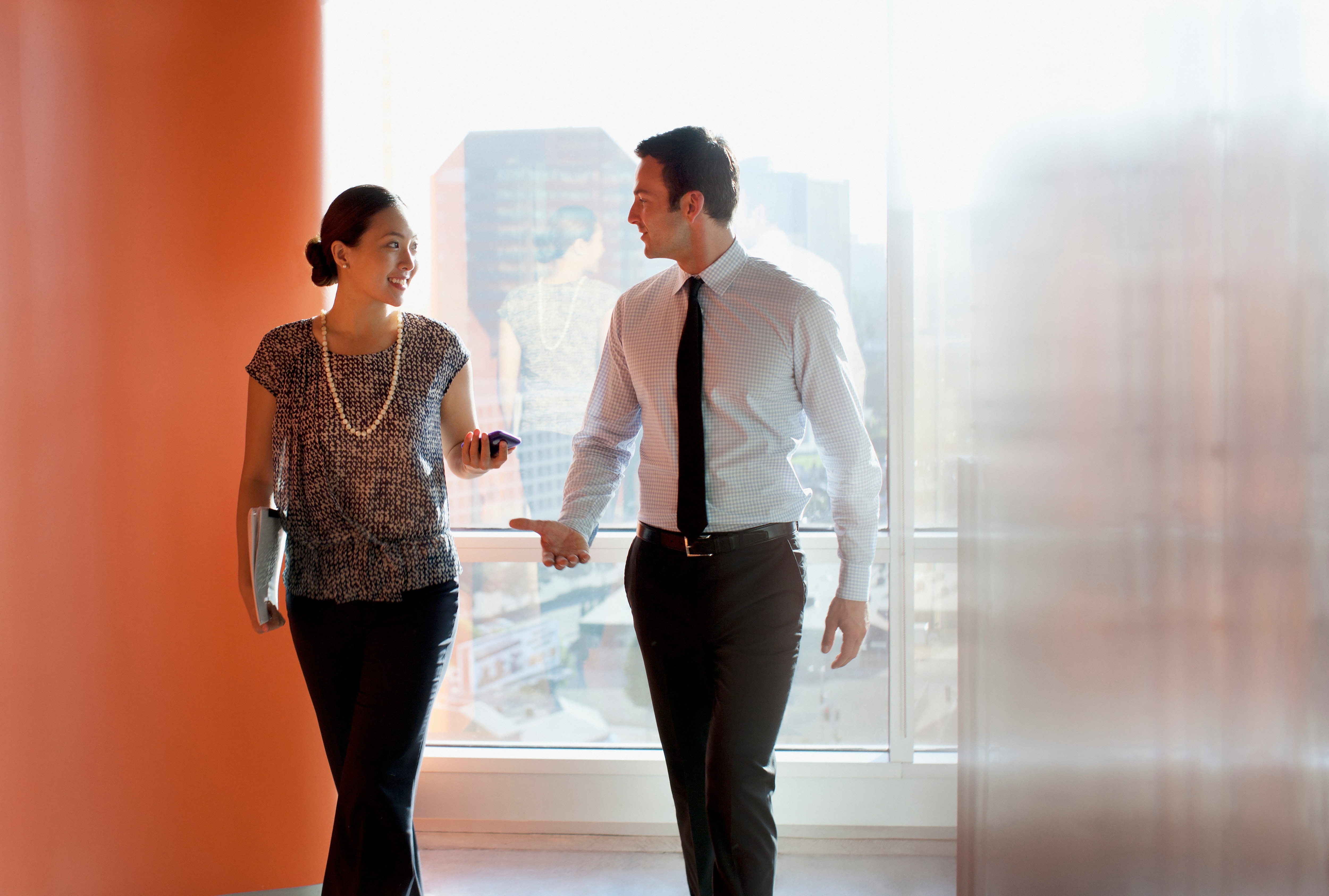 two coworkers walking in the office together