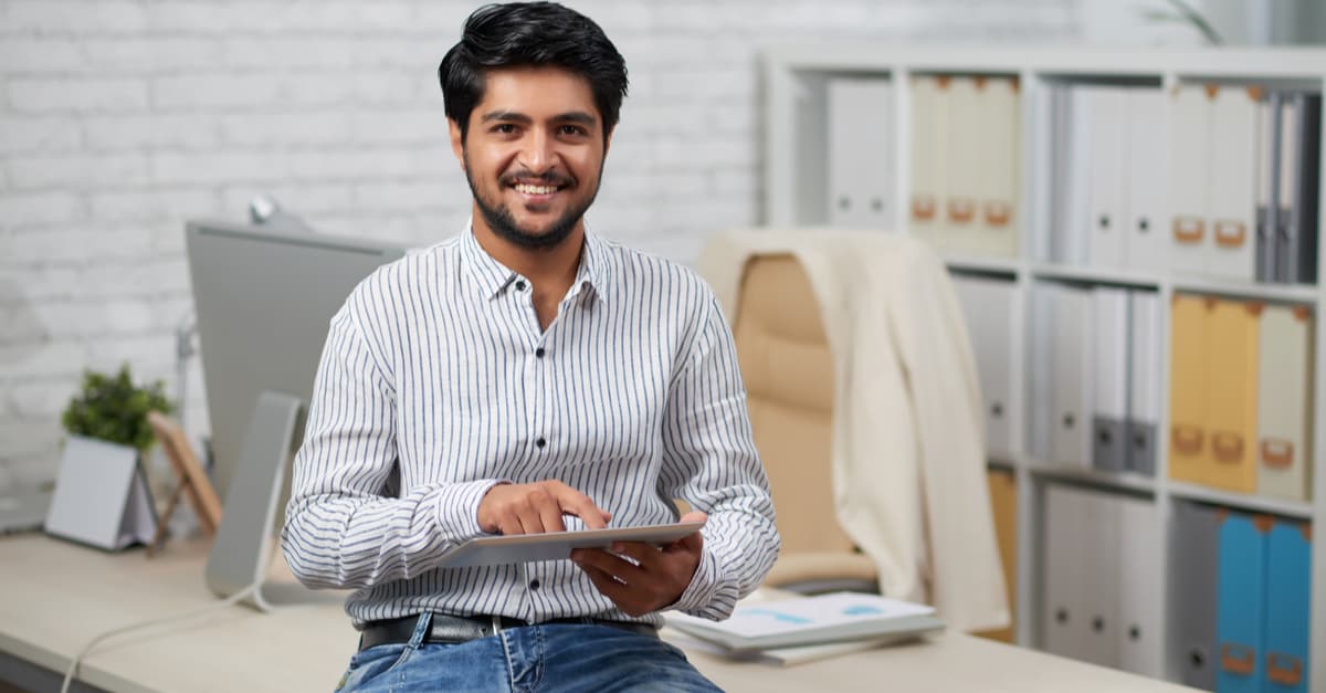 man smiling with a tablet in his hands