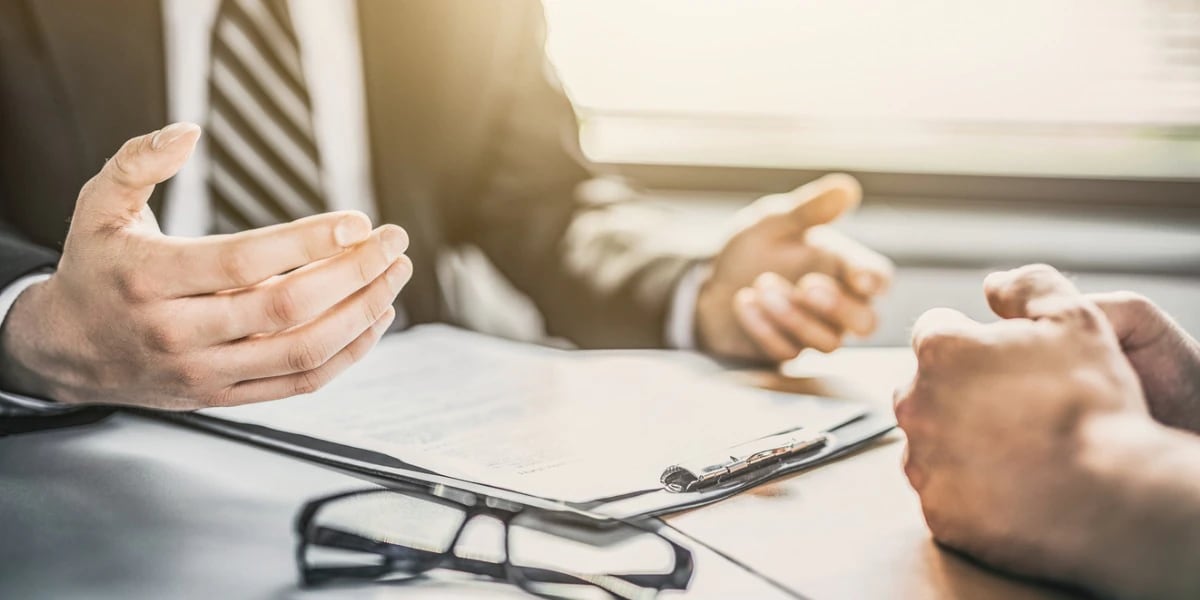 two business people chatting with paperwork in front of them on a table