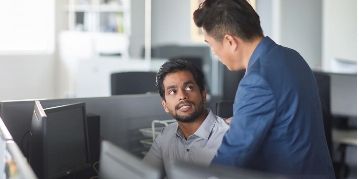 Two businessmen working together on a laptop