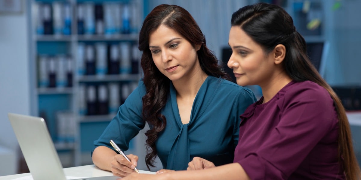two business women collaborating on a laptop