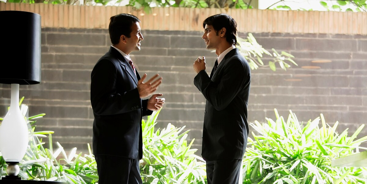 Two men in suits speaking to each other