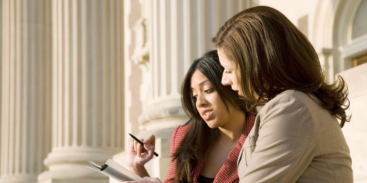two women looking at a document 