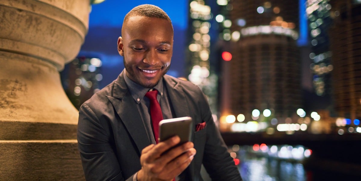 professional man sitting outside, using cell phone