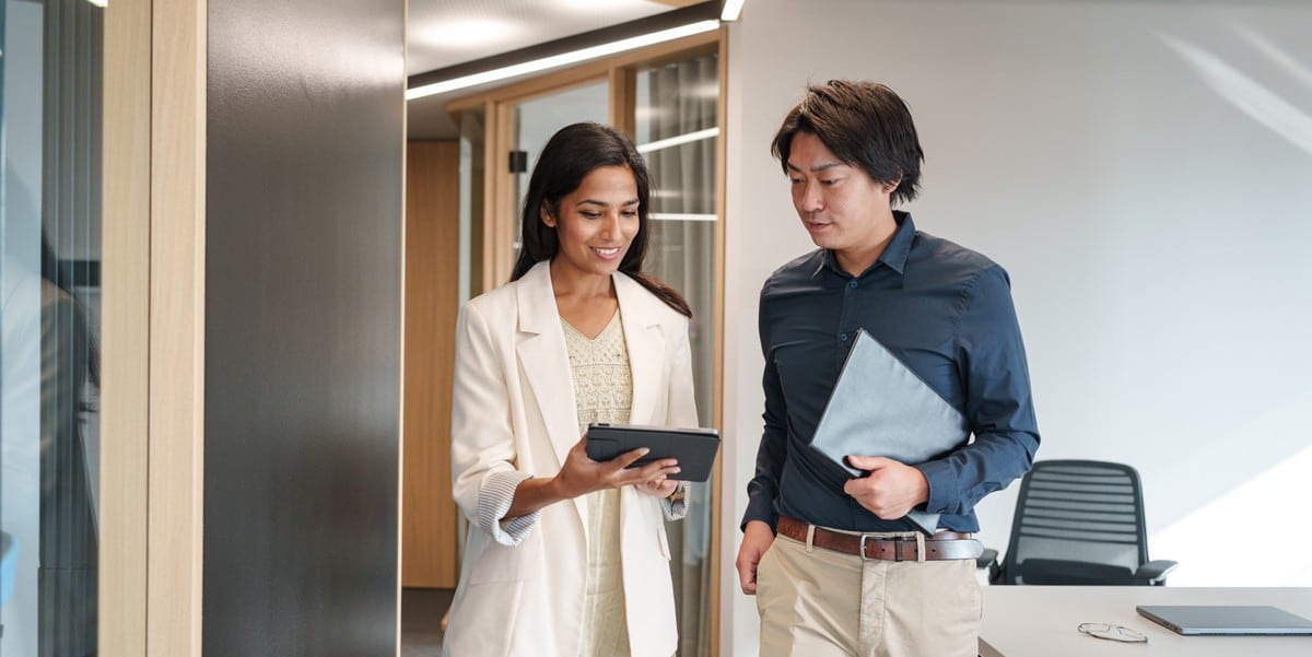 two professionals in the office looking at tablet