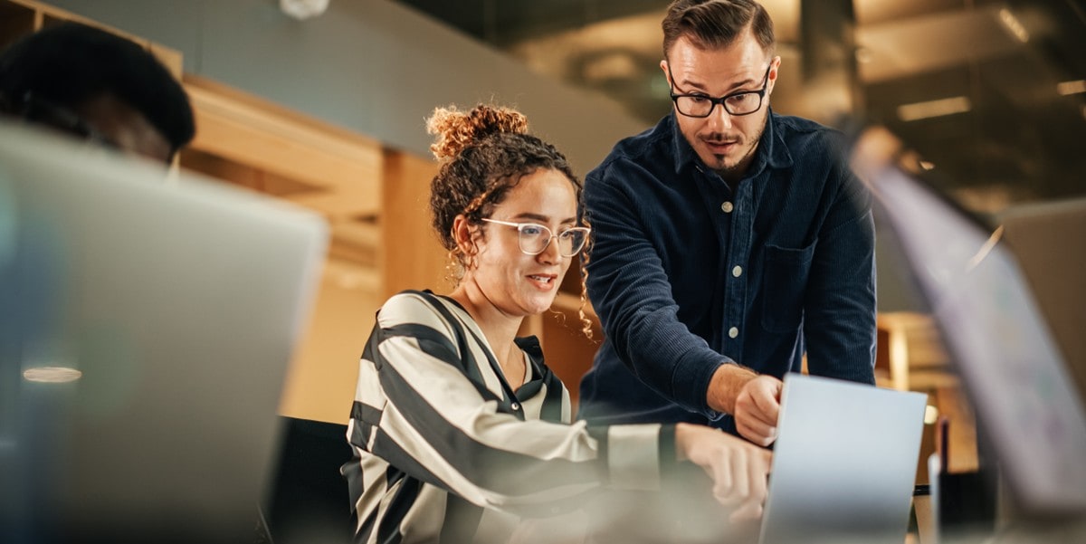 two professionals in the office looking at computer screen