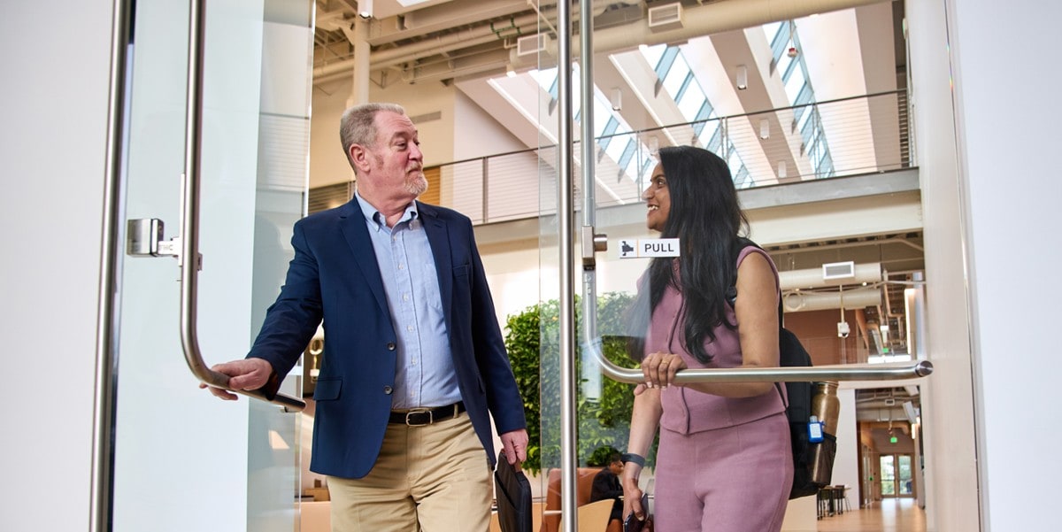 two professionals walking out an office door