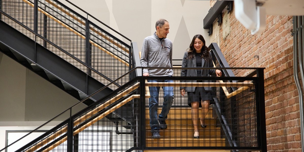 two professionals walking downstairs in an office