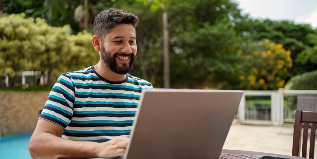 man working on laptop, sitting outdoors