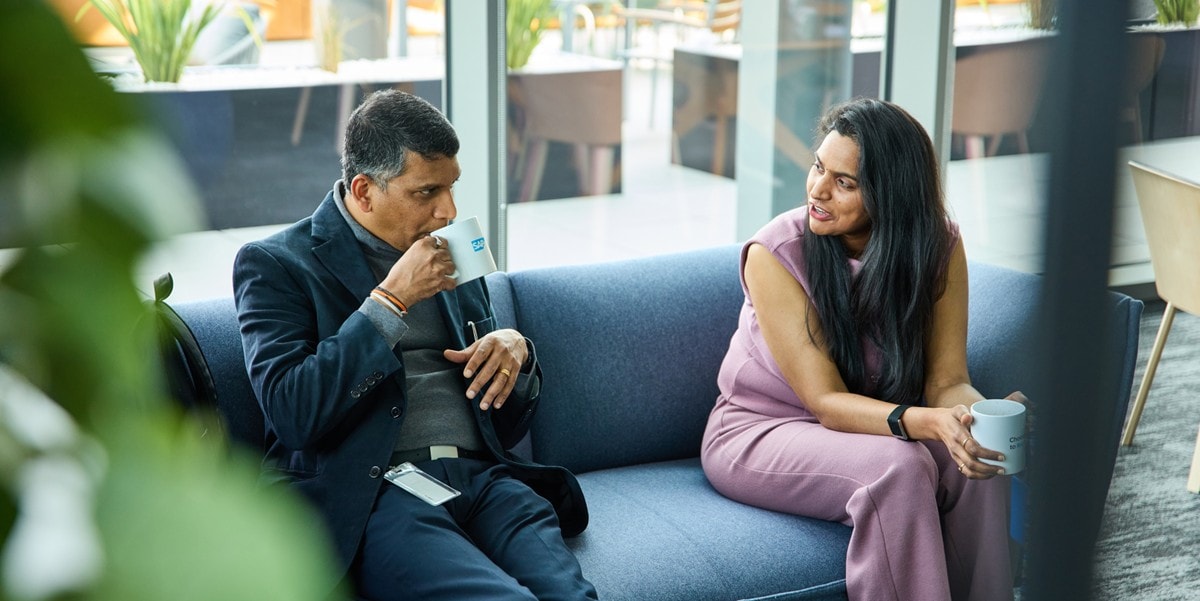 two businesspeople meeting at the office, sitting on sofa