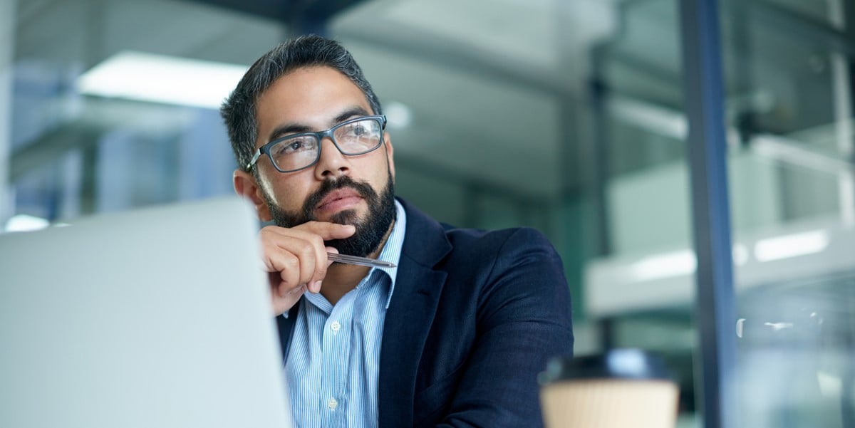 professional man working at desk, laptop in front of him