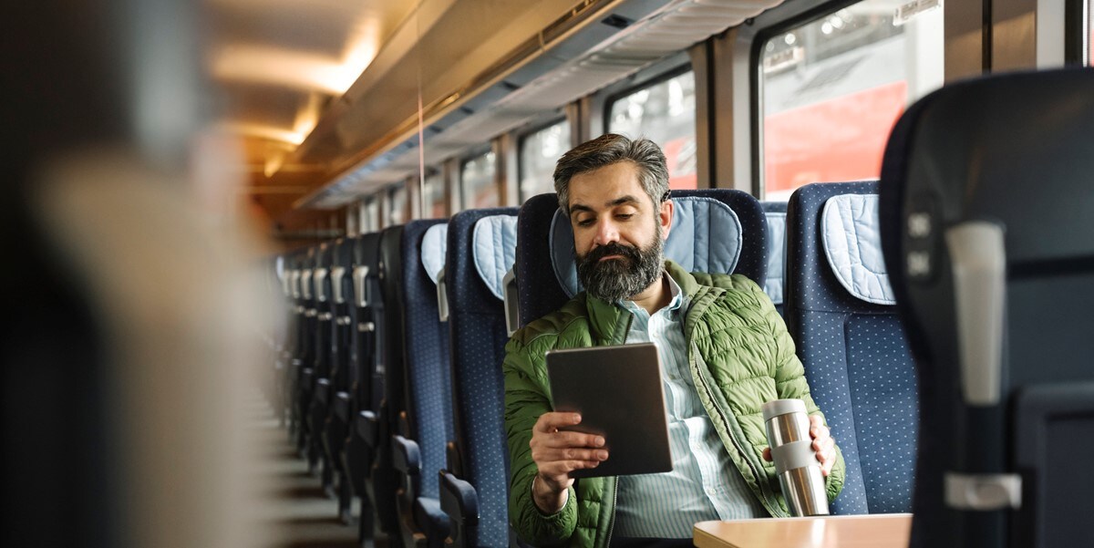 traveler on a train, looking at phone in hand