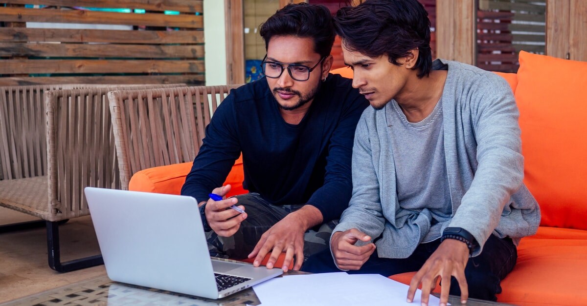 two people looking at a laptop together
